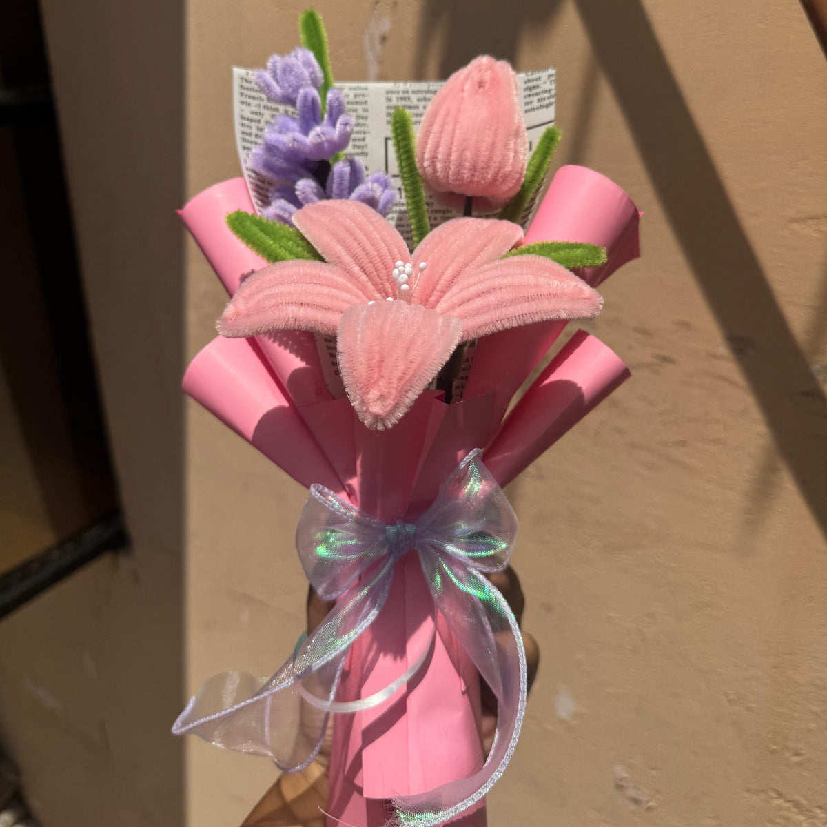 Bouquet of pink flowers with a decorative bow on a plain background